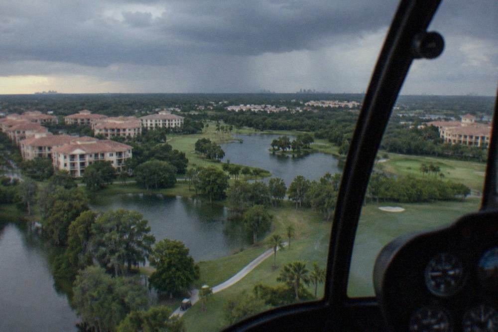 Aerial view of lakes and resort rooftops along the Orlando theme park corridor from a helicopter window
