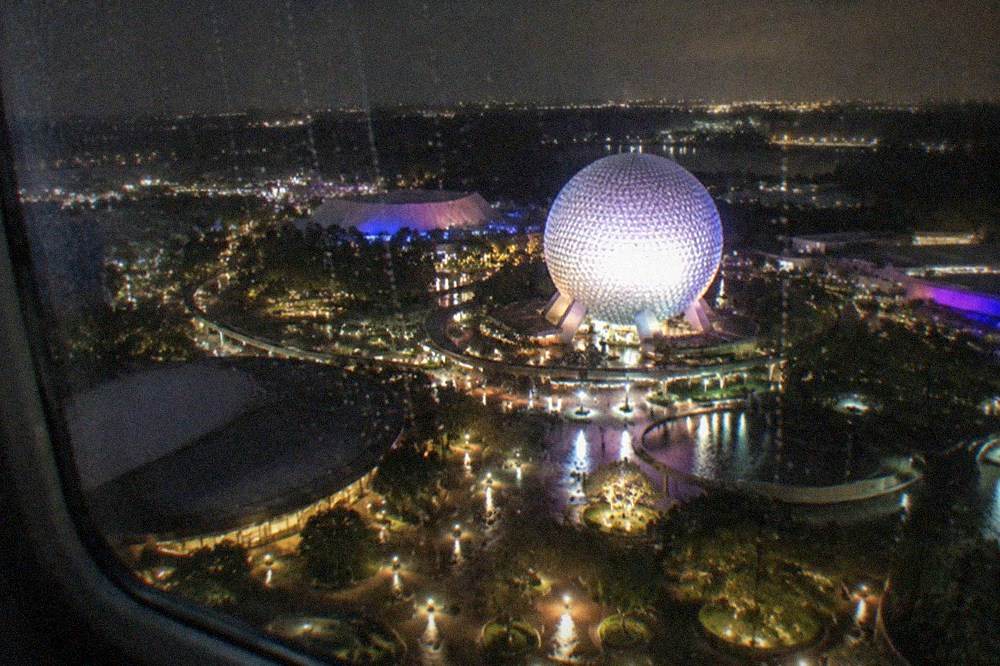 Theme park towers and resort lights glowing at night seen from above