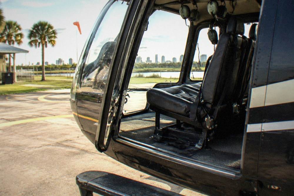 An open door of a small tour helicopter with empty passenger seats visible inside