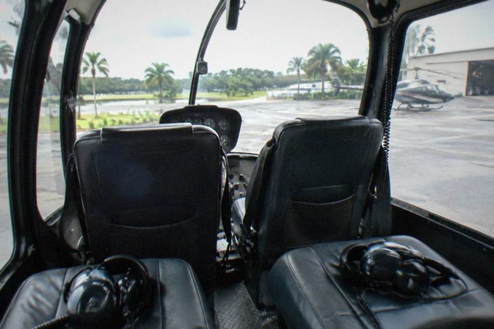 A tour helicopter cabin interior with large windows and forward passenger seats