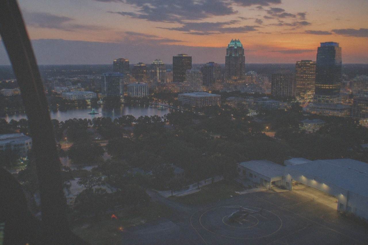 Orlando skyline glowing with lights at dusk seen from above