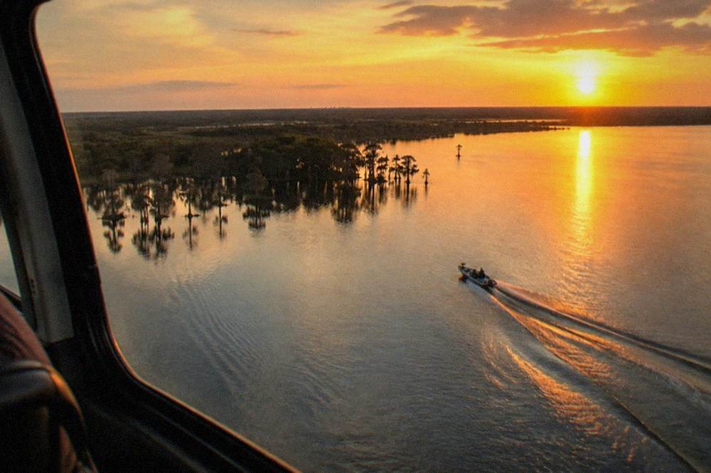 Golden sunset light across a Florida lake with a helicopter window frame in the foreground