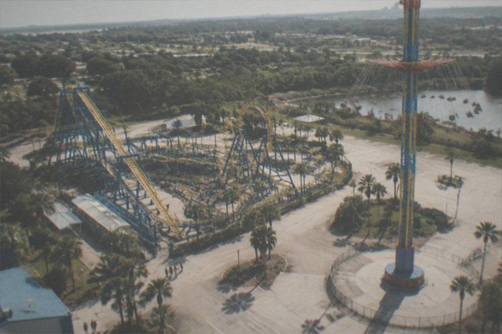 Aerial view over Kissimmee amusement park rides and surrounding Florida landscape
