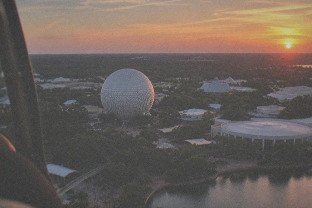 Sunset light over Central Florida lake and distant theme park skyline from the air