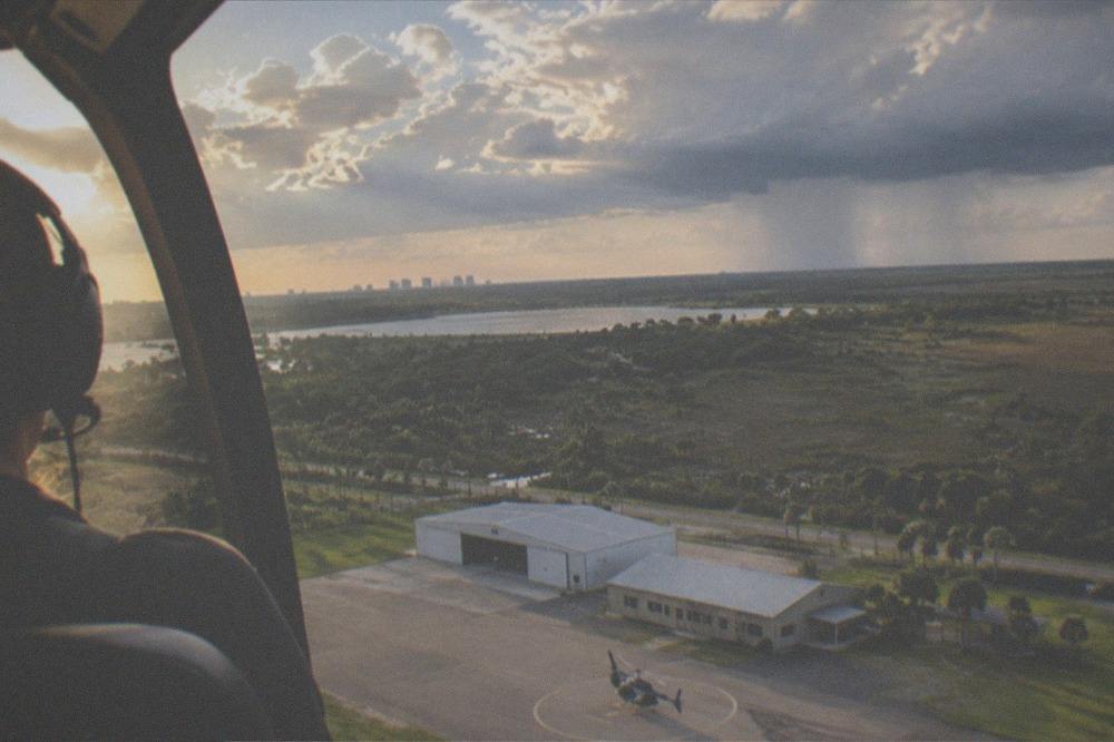 A helicopter flying above Florida clouds in late afternoon light