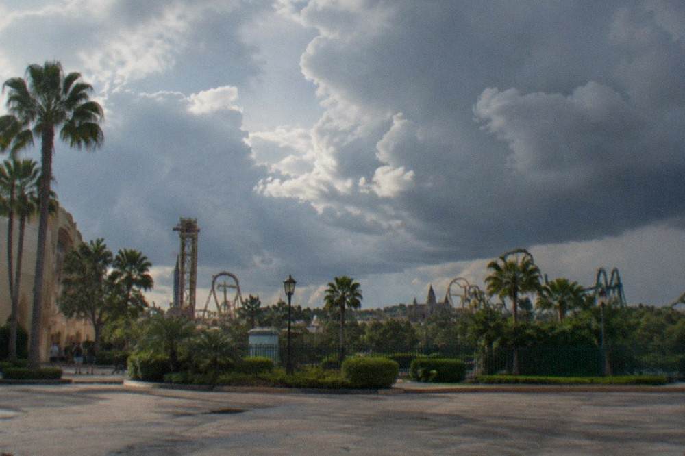 Dark storm clouds building over a flat Florida horizon near theme park towers