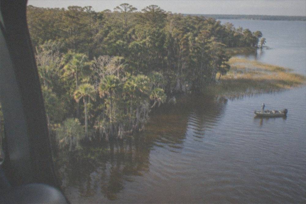 Helicopter flying over lakes and wooded Florida landscape in morning light