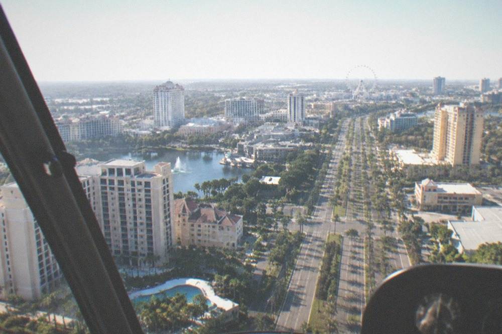 Aerial view of the International Drive corridor with hotels and a large observation wheel in the distance