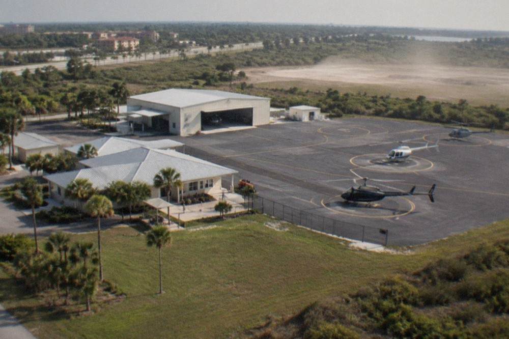 Aerial view of a Florida highway corridor with resort hotels and open green land toward the horizon