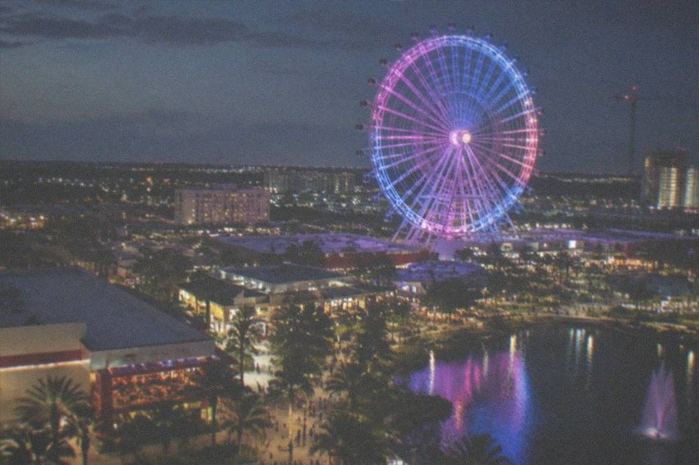 Illuminated observation wheel and city lights seen from the air on a night flight