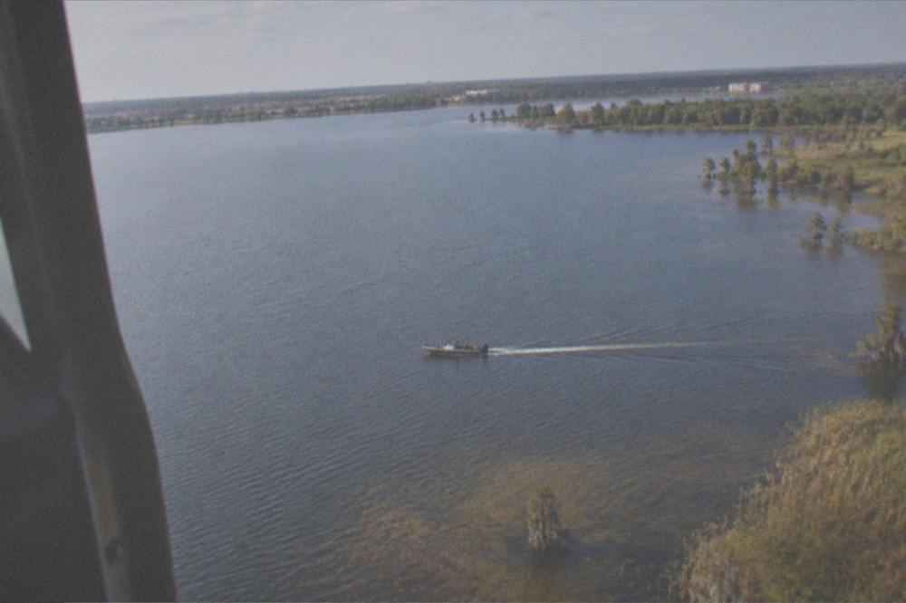 Helicopter in flight above Florida lakes and wooded terrain near the theme park corridor